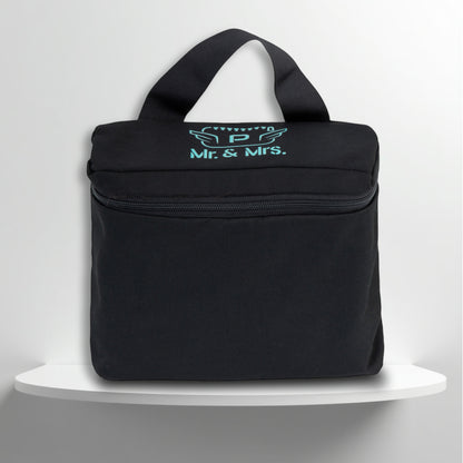 A black cotton travel vanity bag with many Greek travel size personal hygiene products inside for couple
