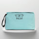 A mint cotton travel vanity bag with many Greek travel size personal hygiene products inside